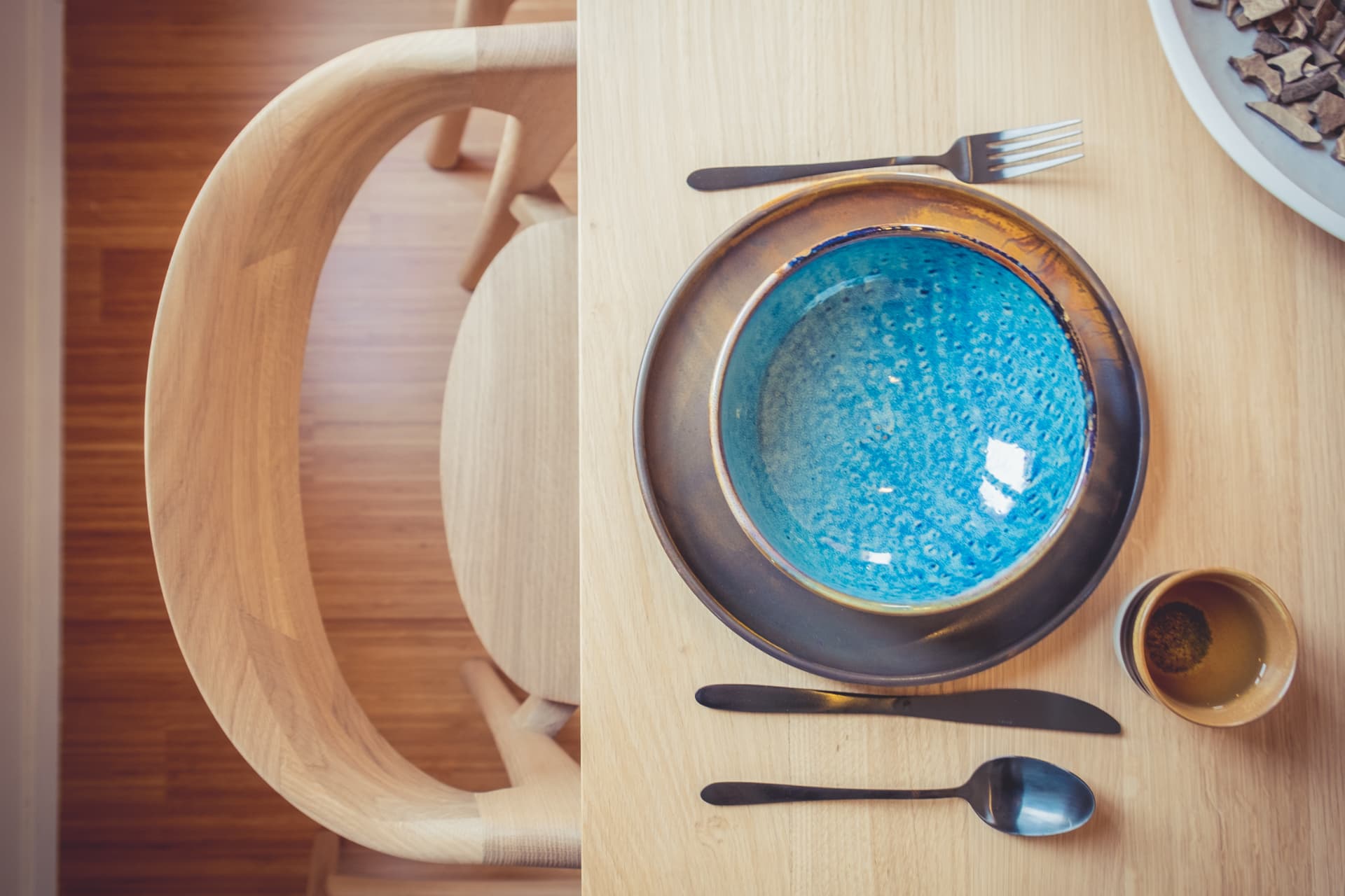 Tafeldekking met blauw aardewerk op eiken tafel